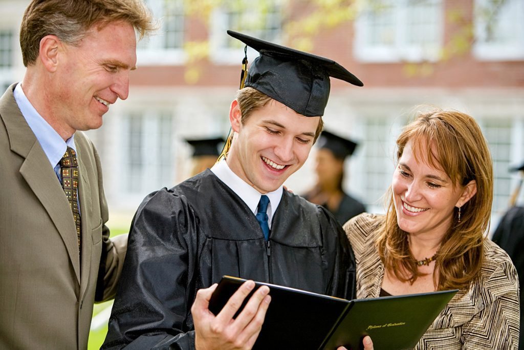 Happy parents speak to their freshly minted college graduate.